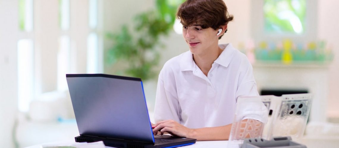 Boy Using Computer For Online Homeschool